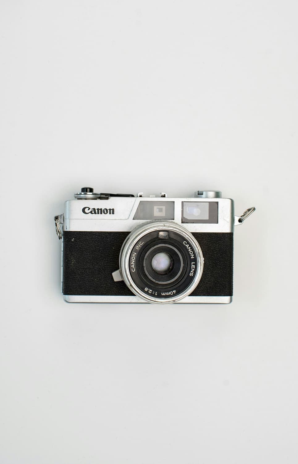 Vintage silver rangefinder camera on a light grey background