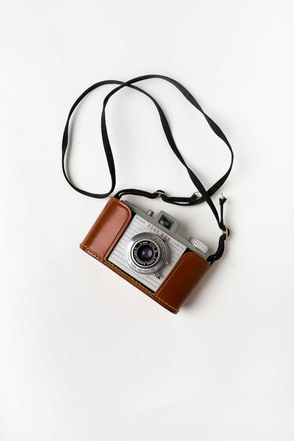 Vintage film camera in a leather case on a white surface