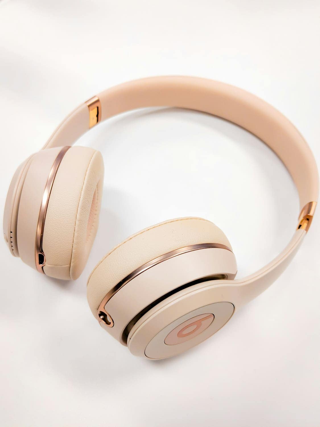 Beige wireless headphones on a white surface