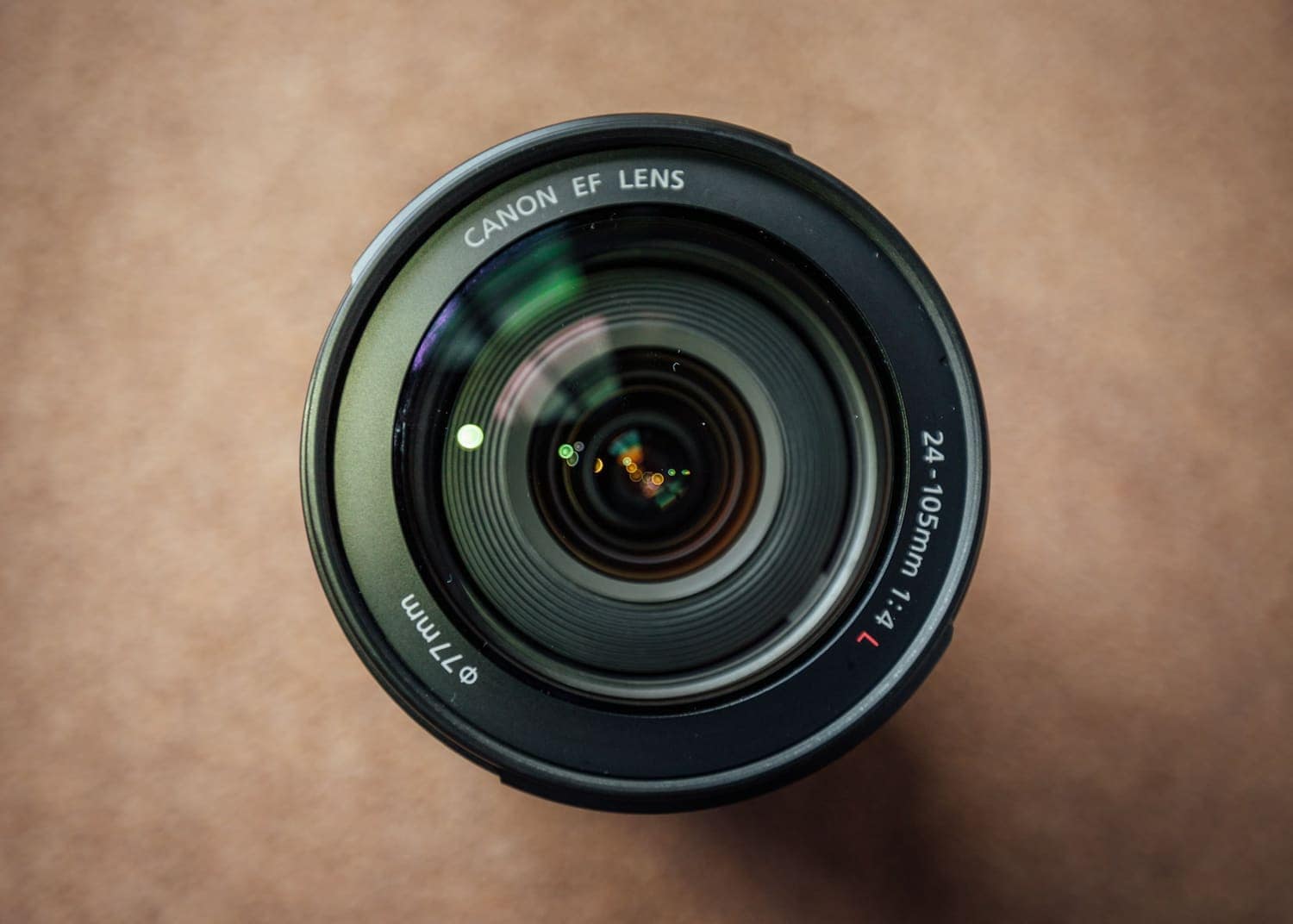 A camera lens seen from above on a warm brown surface